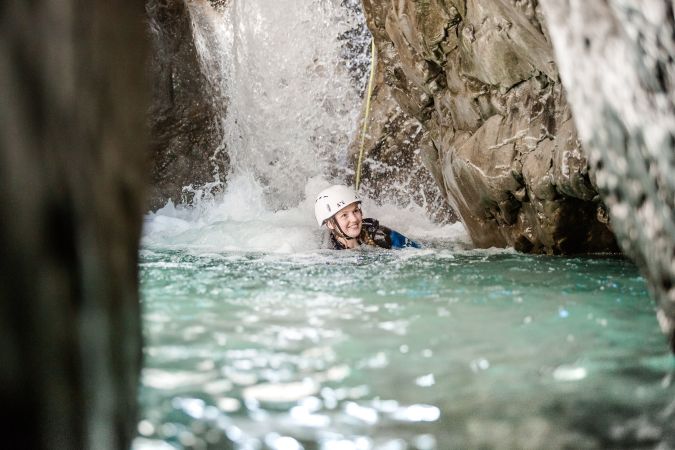 Teilnehmer beim Sprung in einen Naturpool in der Schlucht
