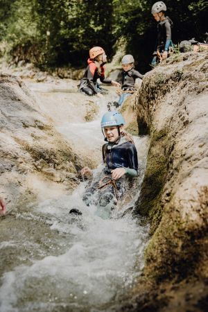 Kinder mit Guide beim Canyoning in einer Schlucht bei Lofer