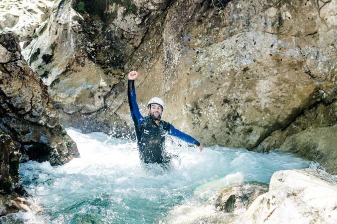 Guide sichert Teilnehmer beim Abseilen in der Schlucht
